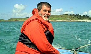 Photo of David Hogan at the tiller of a sailing boat