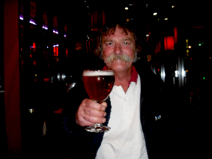 Portrait of Graham Cole holding forward a goblet of expensive beer