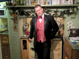 Photo of Iain Mackenzie looking splendid in crimson embroidered waistcoat reclining against an Aga
